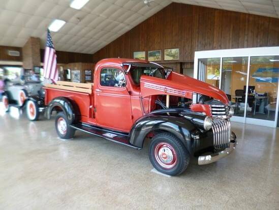 Red vintage pickup truck in an indoor showroom
